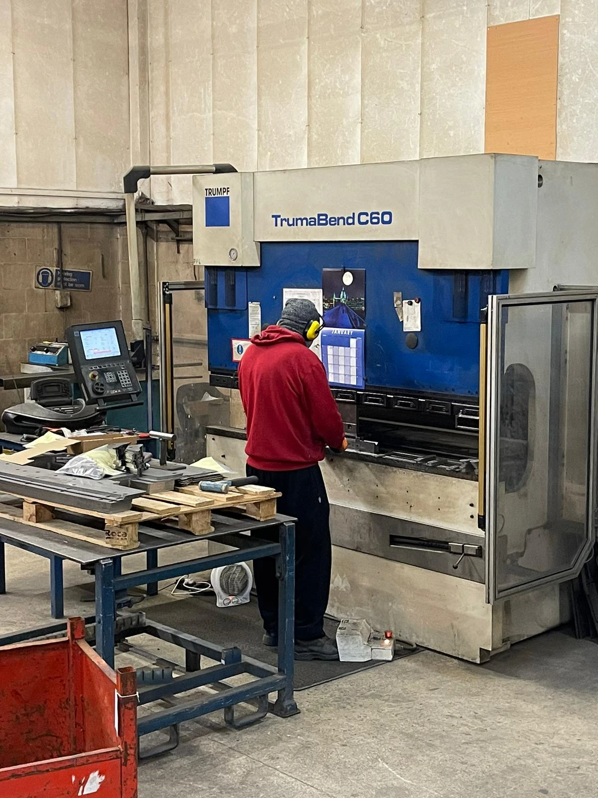 A Summit Engineering employee in blue overalls operates a 60 ton Trumpf TrumaBend C60 press.
