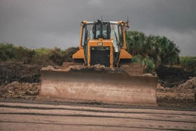 A bulldozer is driving through mud