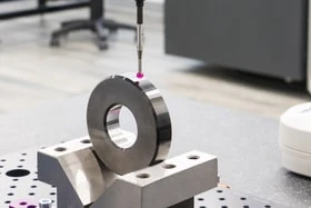 High precision inspection probe touching a metal ring in a metrology lab